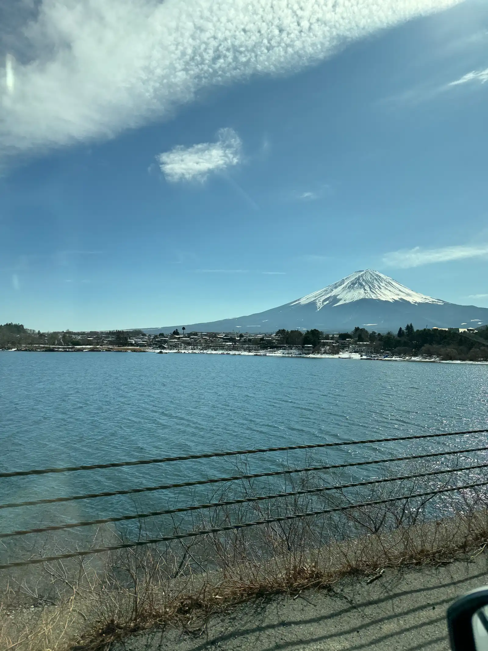 Snow-capped Mount Fuji over Lake Kawaguchi with a lakeside town at its base