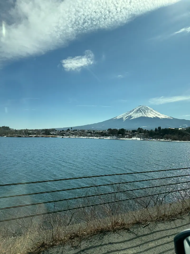 Snow-capped Mount Fuji over Lake Kawaguchi with a lakeside town at its base