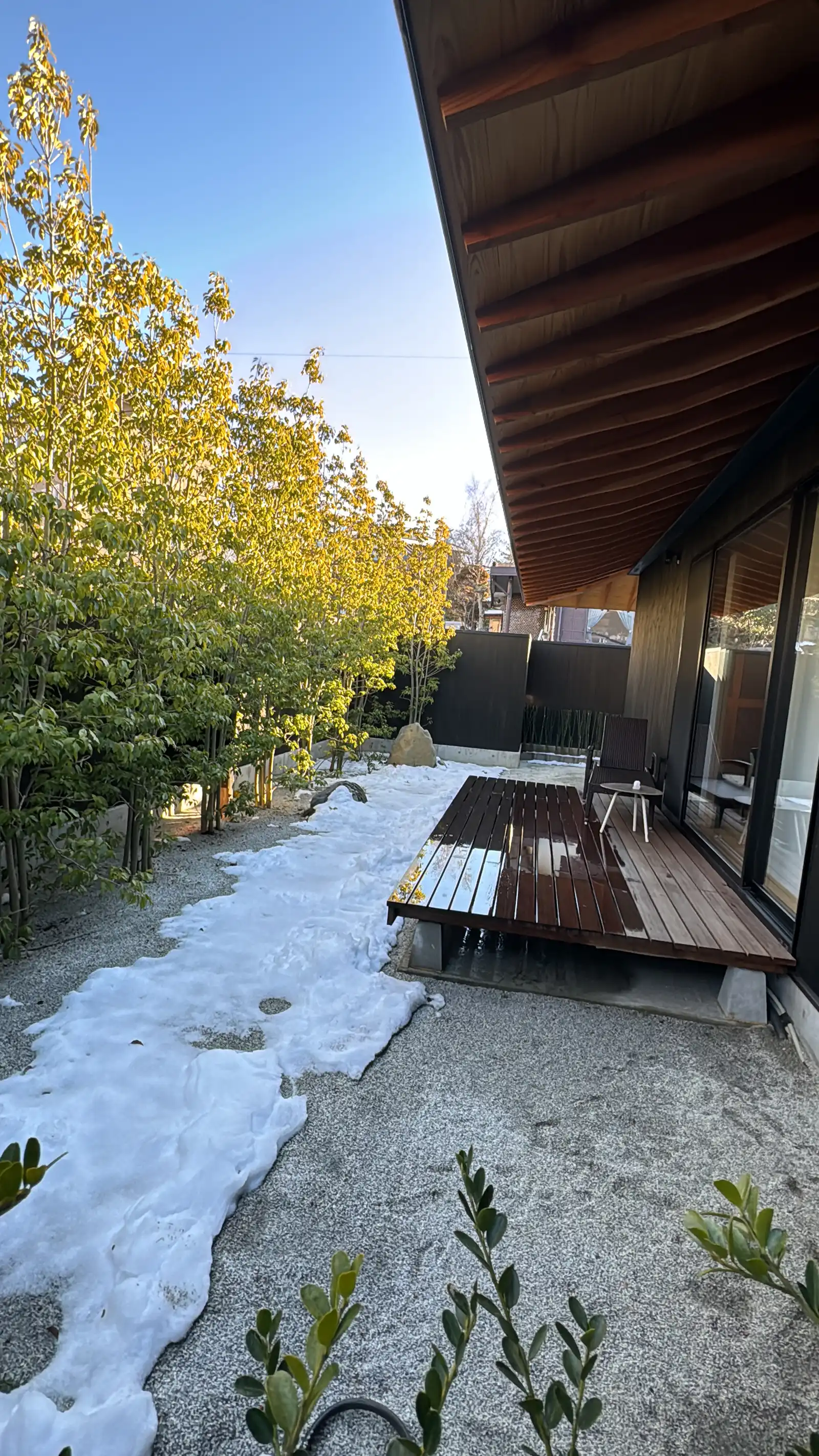 Wooden deck and snowy gravel garden beside a Japanese lodge in Kawaguchiko