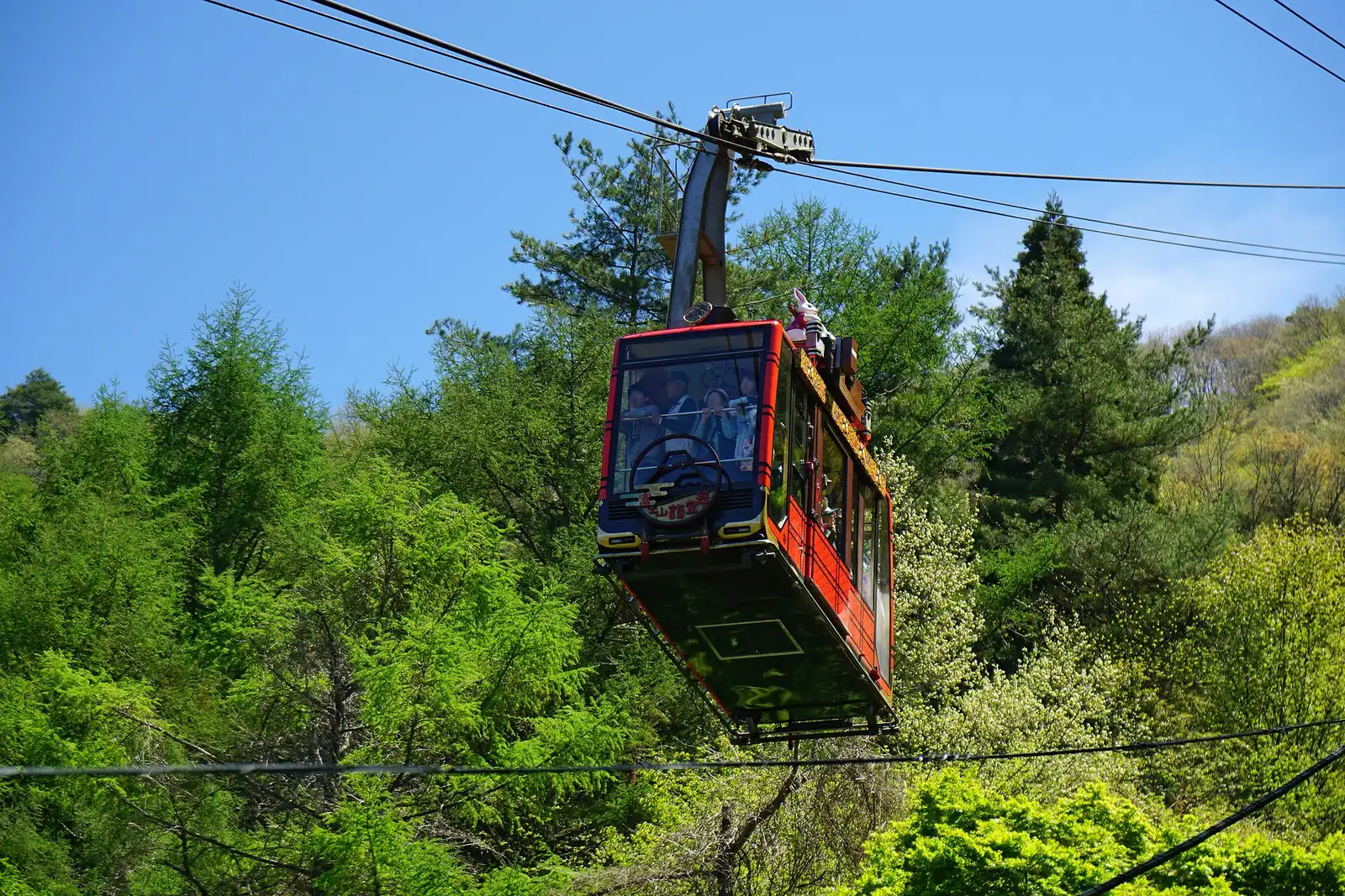Red Kachi Kachi Ropeway gondola among spring trees
