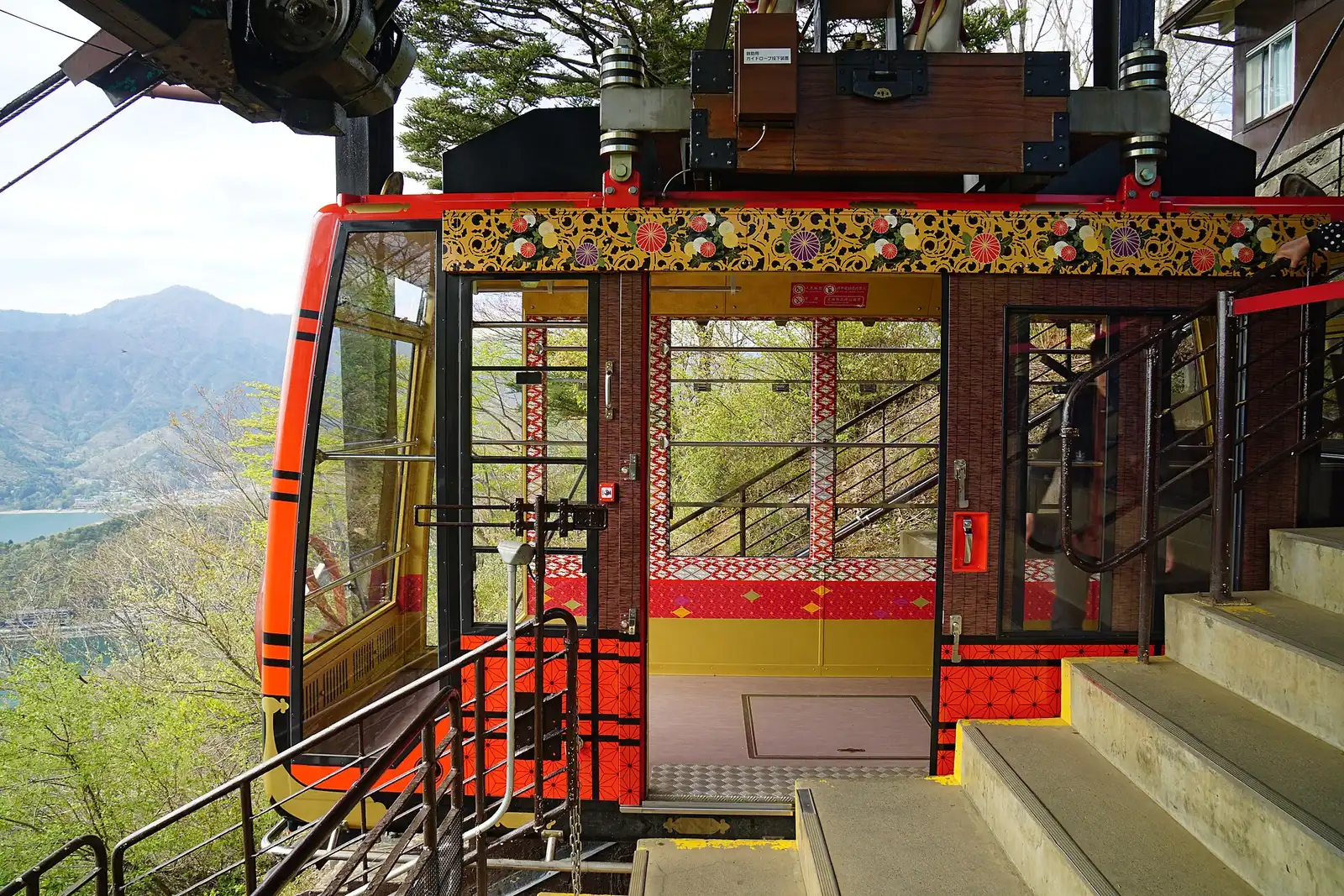 Red ropeway gondola docked at the station, doors open