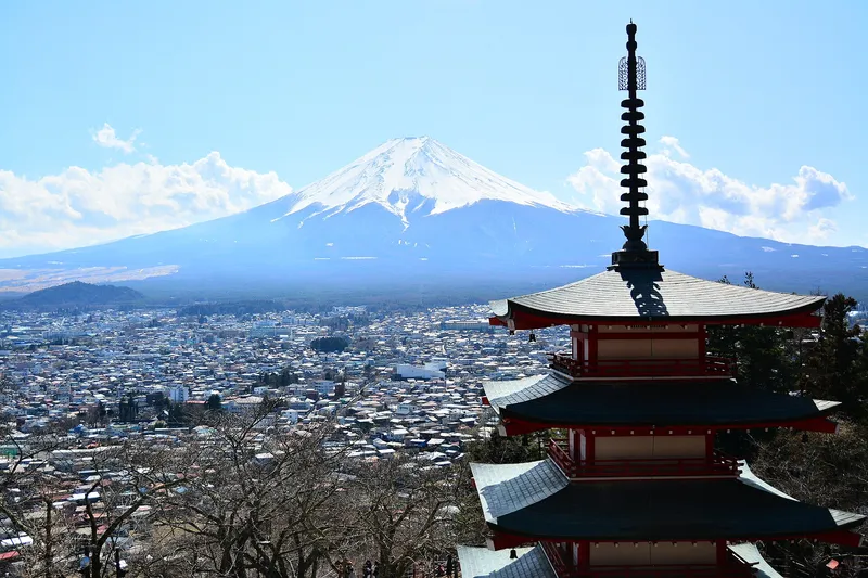 Snow-covered Mt Fuji above Fujiyoshida town, the top of Chureito Pagoda in front