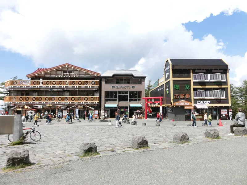 Lodges and red torii across the lava-stone plaza at the Fuji Subaru Line 5th Station