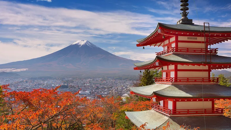 Chureito Pagoda with red autumn leaves, Mt Fuji and Fujiyoshida town behind
