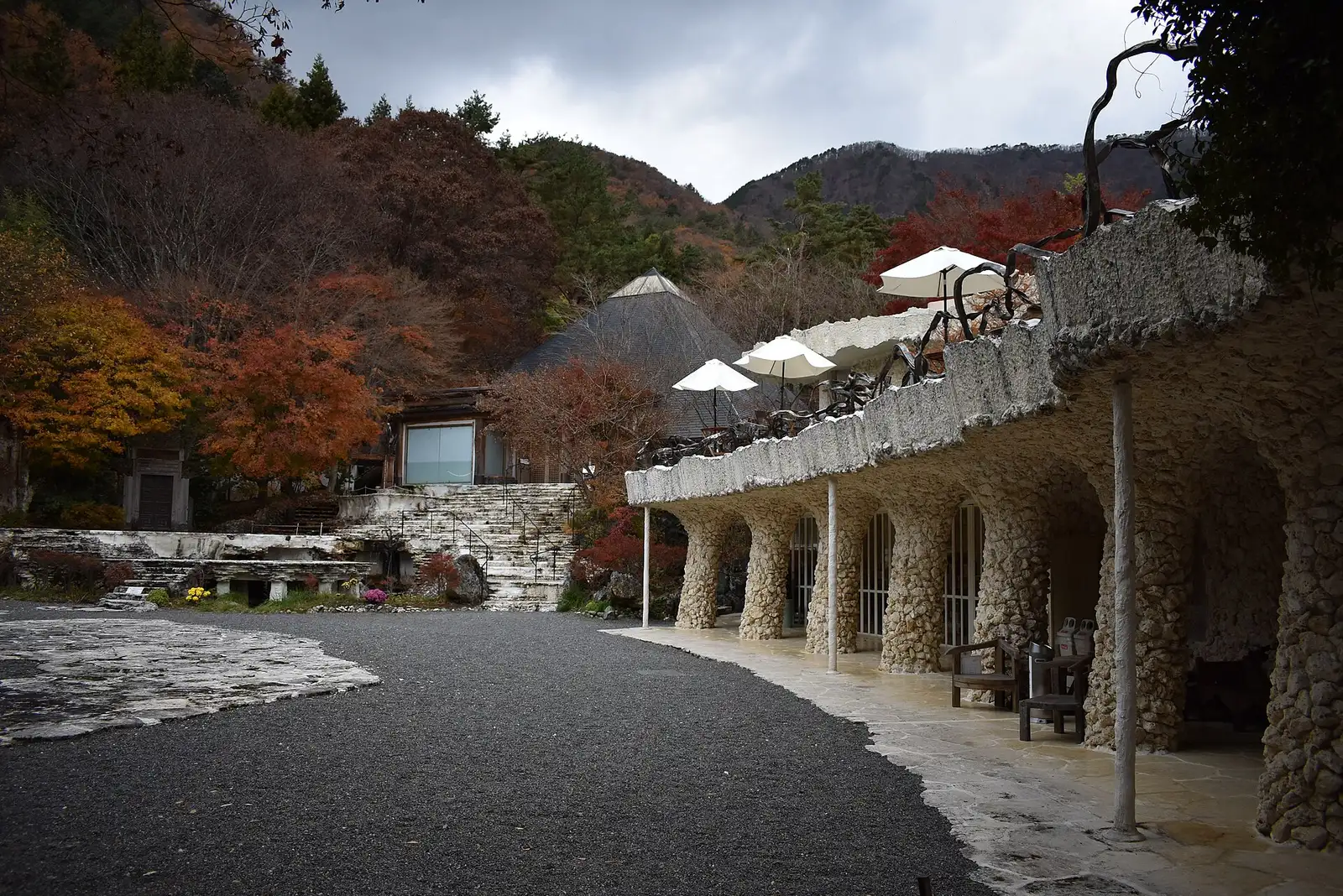 Coral-stone colonnade and pyramid-roof hall of the Itchiku Kubota Art Museum in autumn